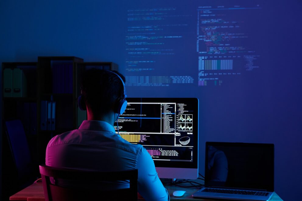 man on computer in dim room